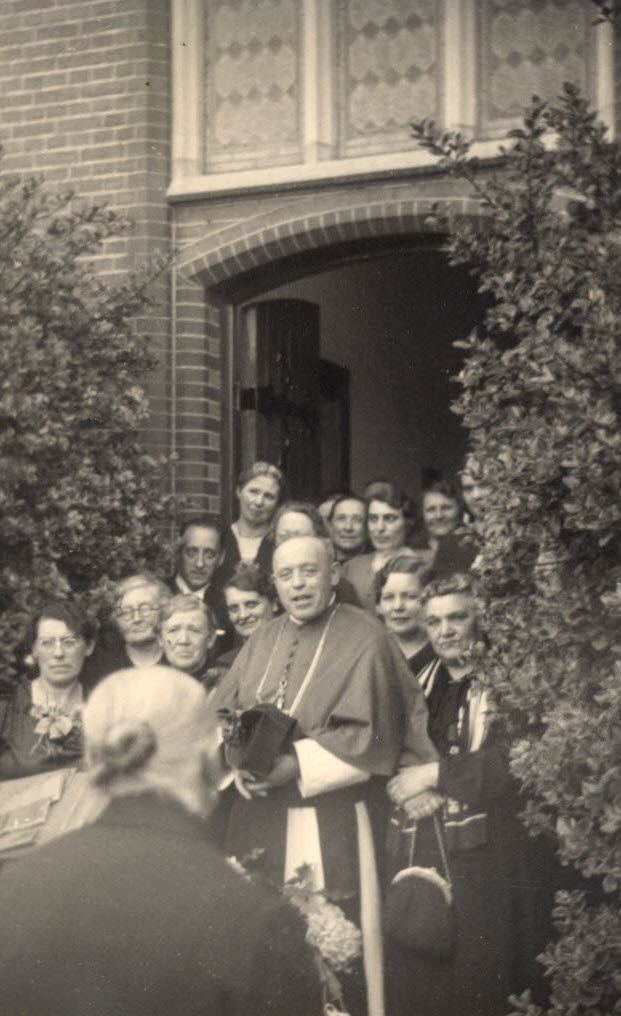 groepsfoto voor de open kloosterdeur van de mgr en zijn familie