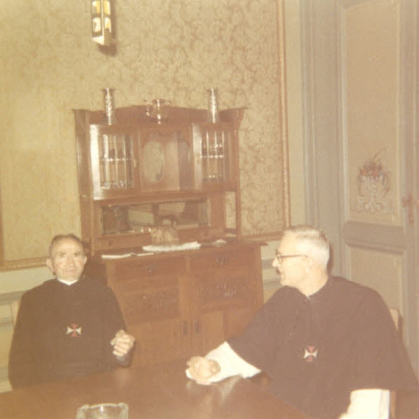 Twee kruisheren in habijt aan een tafel