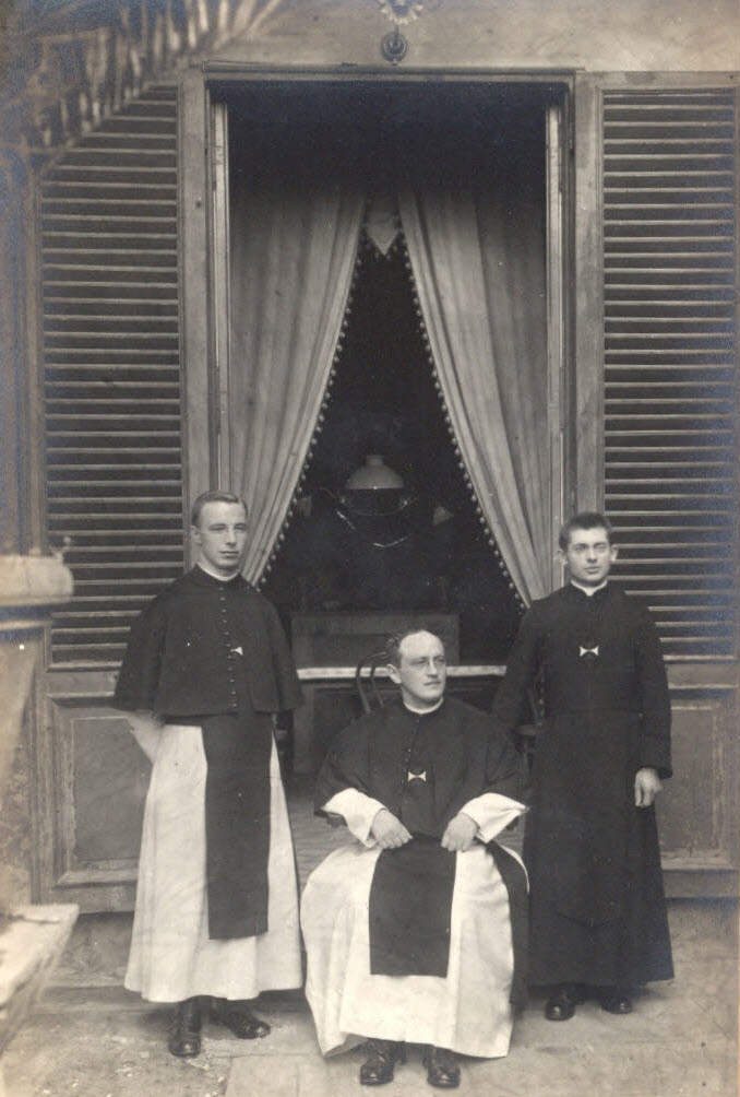 drie kruisheren in habijt poseren voor een gevel
