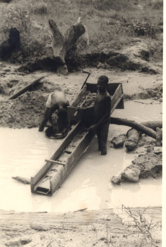 missiefoto uit Bondo van twee mannen met een spoeltrog in een waterstroom